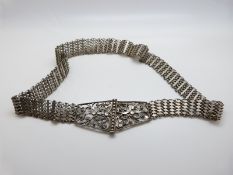 A white metal Indian belt with stylised foliate buckle