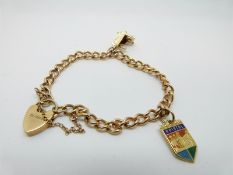A 9ct gold charm bracelet, a 9ct gold Bristol charm and a 9ct gold piano charm, 14.