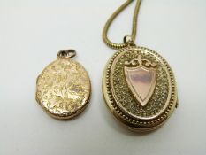 A Victorian yellow metal locket with scrolling decoration,