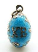 A Russian silver egg pendant set with aqua enamel, 'XB' to one side and a seed pearl to the other,