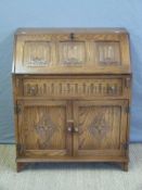 A linenfold carved oak bureau,