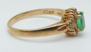 A 9ct gold ring set with an oval emerald surrounded by diamonds, size O, 2.