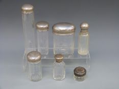 A silver topped dressing table bottle and six plated examples