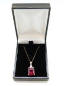 A 9ct gold pendant set with an emerald cut synthetic ruby and diamonds