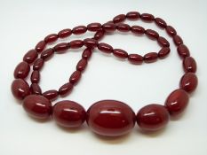 A cherry amber necklace of 47 graduated ovoid beads, the largest approximately 32x24mm, 62g,