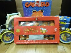 A boxed Garfield ceramic cookie jar together with Garfield alarm clocks, giant watch,