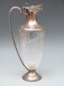 An Edward VII hallmarked silver and glass claret jug with cut glass decoration,