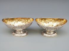 A pair of Georgian hallmarked silver open pedestal salts with embossed decoration and gilt