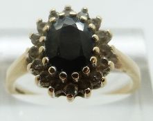 A 9ct gold ring set with a sapphire surrounded by paste, size R/S, 3.