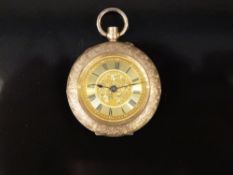 A 14k yellow metal cased ladies fob watch with keyless wind movement and engraved foliate