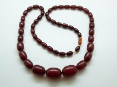 A cherry amber necklace of graduated beads, the largest approximately 2.5cm x 1.