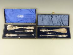 A cased hallmarked silver handled button hook / shoe horn set and another set with Art Nouveau
