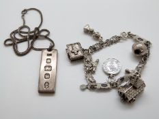 A silver charm bracelet and silver ingot