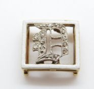 A Victorian buckle set with white enamel border and an inset diamond D in Asprey box