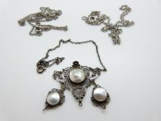 A silver necklace set with three mother-of-pearl cabochons and two chains