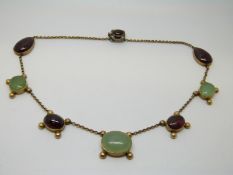 A Victorian necklace set with alternating green and red cabochons in foiled settings