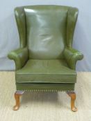 A green leather wing back armchair