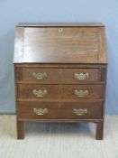 An oak bureau, the fall flap opening to reveal fitted interior, the base fitted three drawers,