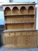 A pine dresser with plate rack above also having eight small drawers to top,