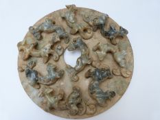 A Chinese jadeite style disc with applied decoration depicting chilong,