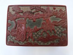 A late 19th / early 20thC cinnabar box with carved decoration of a warrior on horseback and