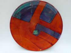 A large Poole pottery charger decorated with a geometric design,