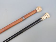 A walking stick with ivory top banded with ebony and a Chinese example with resin top depicting