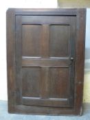 An antique oak housekeeper's cupboard with peg jointed panelled door,