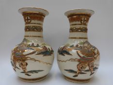 A pair of 20thC crackle glaze vases with gilded decoration of warriors,
