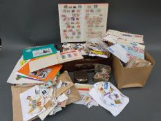 A suitcase containing tins of loose stamps, other loose stamps,