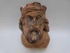 A wall mountable stone bust in the form of a man with a beard and long hair wearing a crown,