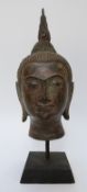 An early Tibetan Buddha head on plinth,