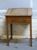 A 19thC oak clerk's desk with lift up flap and two drawers below,