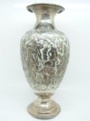 A Persian or similar eastern white metal vase decorated with figures, camels, vessels and dogs,