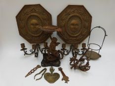 A pair of embossed metal wall candle sconces with sun mask decoration together with a pedestal dish