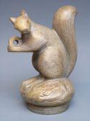A car mascot formed as a squirrel holding a nut,
