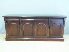 A four door sideboard with four drawers above arched panelled doors,