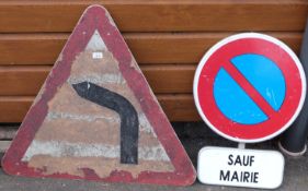 A 'bend' road sign and a 'Sauf Mairie' sign