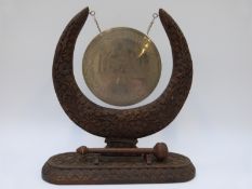 An early 20thC Indian gong with carved wooden stand and engraved silver plated centre depicting the