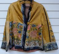 A late 19thC Chinese silk jacket embroidered with flowers in coloured thread on yellow ground,