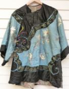 A late 19thC Chinese coat embroidered with flowers in coloured thread on blue ground with pink silk