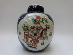 A Chinese ginger jar with a blue ground decorated with vases and flowers in white cartouches,