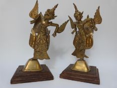 A pair of Indonesian or Thai brass figures of winged deities mounted on wood plinth bases,