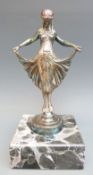 A car mascot formed as an Art Deco girl holding her dress, marked to base Finnigans London, 7/25,