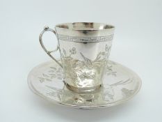 A late 19thC /20thC Chinese silver cup and saucer with engraved decoration of seated figures with a