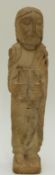 A medieval carved limestone Romanesque figure of a robed man holding a book,