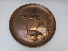 A large Japanese bronze charger with relief decoration of birds,