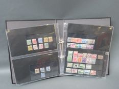 An assortment of Commonwealth stamps Victoria-George VI mint and used in a ring binder