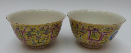 Two Chinese tea bowls with floral decoration on a yellow ground