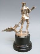 A car mascot formed as a British WWI soldier pointing a rifle at an eagle wearing a Pickelhaube